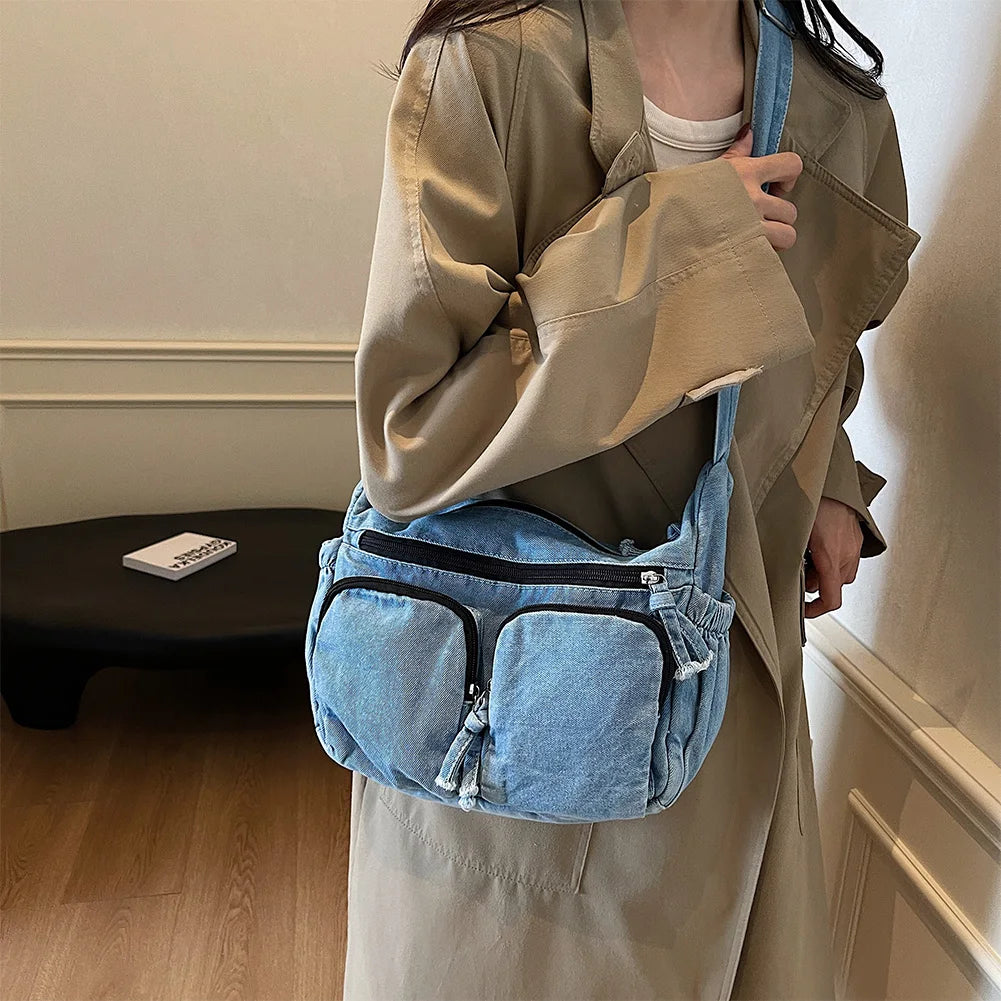 Denim shoulder bag with front pockets and buckle strap