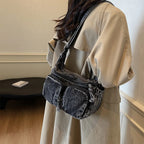 Denim shoulder bag with front pockets and buckle strap