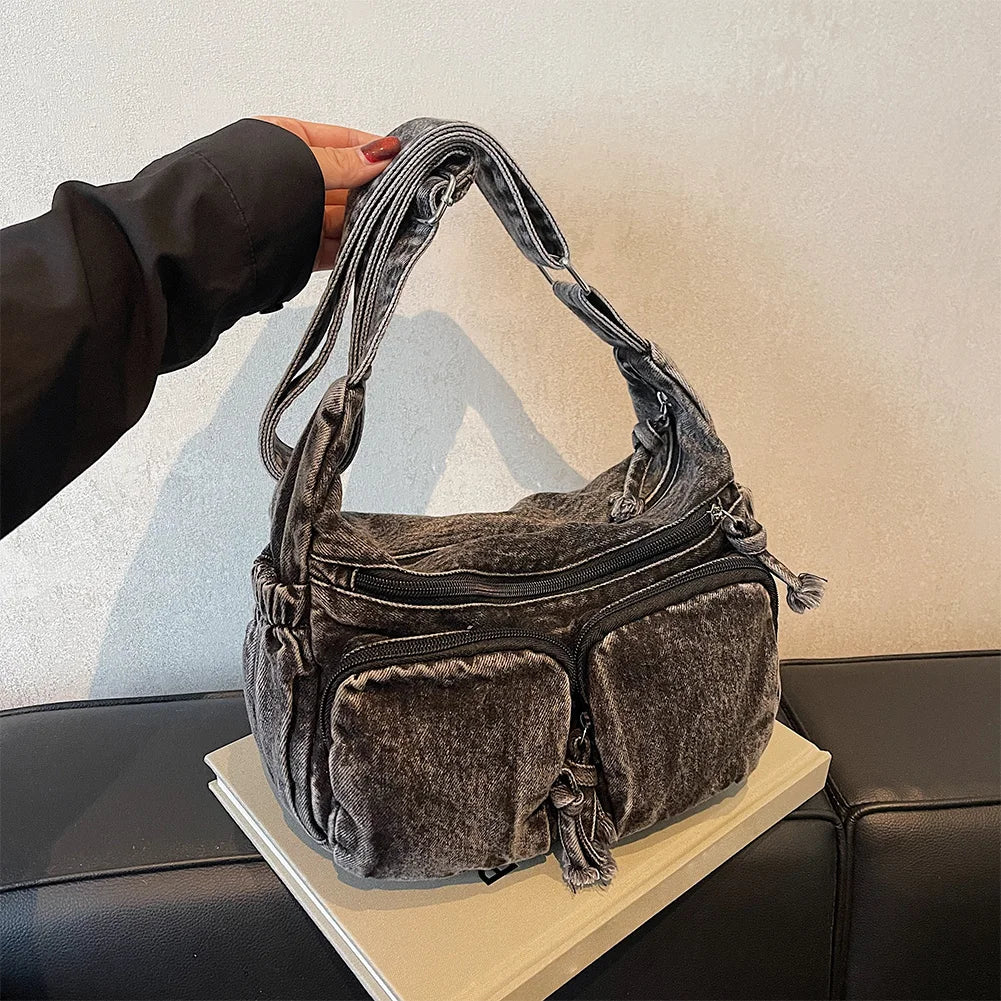 Denim shoulder bag with front pockets and buckle strap