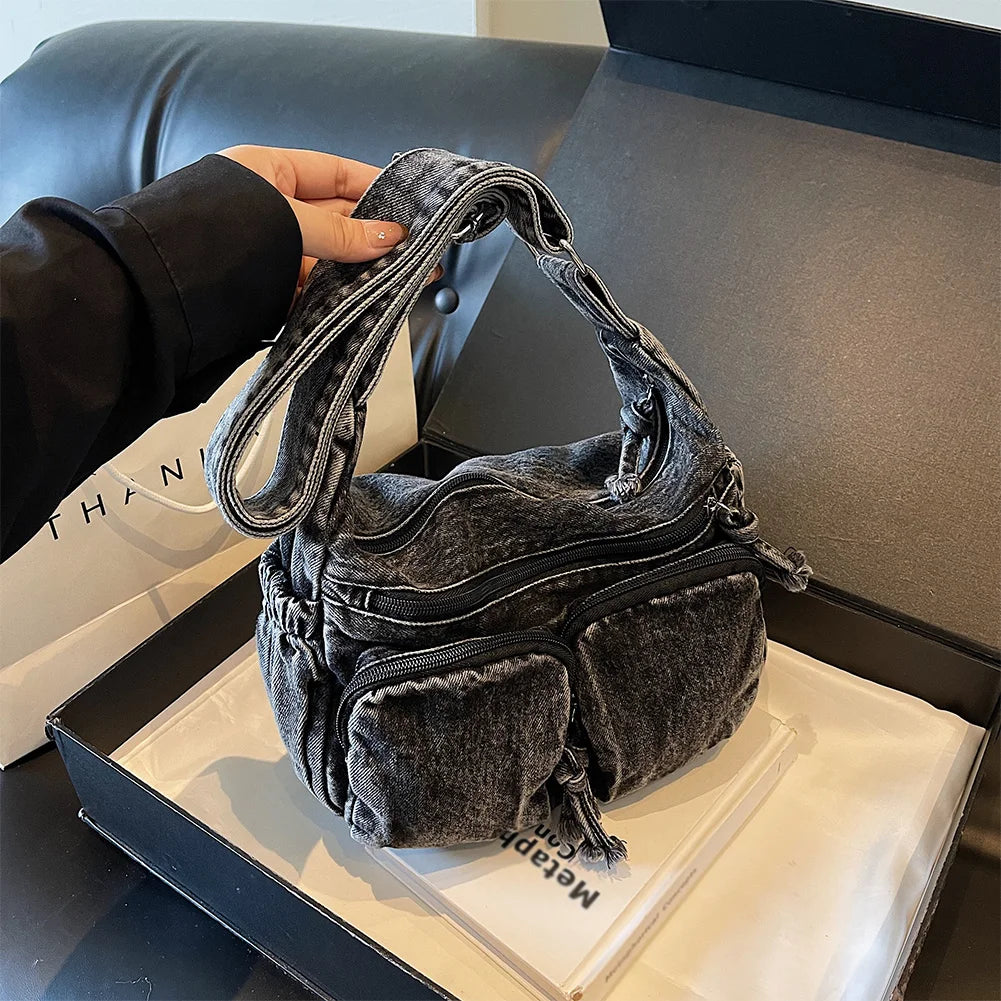 Denim shoulder bag with front pockets and buckle strap