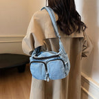 Denim shoulder bag with front pockets and buckle strap