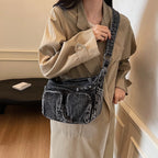 Denim shoulder bag with front pockets and buckle strap