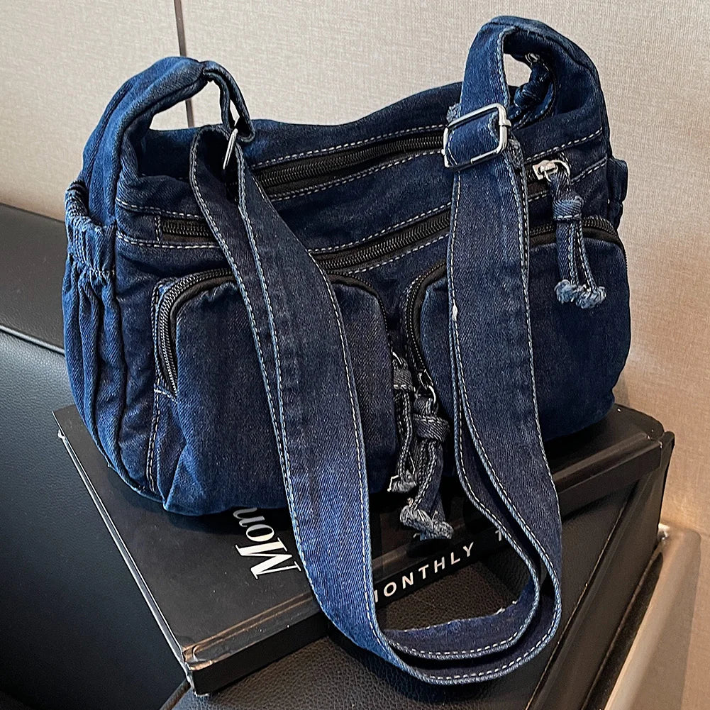 Denim shoulder bag with front pockets and buckle strap